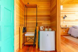 a small refrigerator in a room with wooden walls at Pousada Bracatinga in Bom Retiro +39 photos
