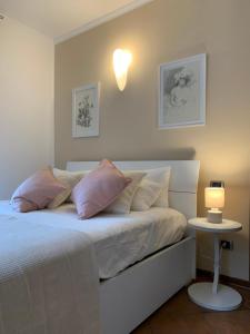 a bedroom with a bed with pink pillows and a table at La Villa Como in Como