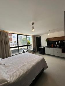a bedroom with a large bed and a large window at Bessa Flat Conforto à 180m do Mar - Storey Luxor in João Pessoa