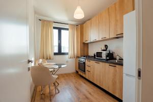 a small kitchen with wooden cabinets and a table at Blvd Ivory Pipera ap 25A in Bucharest