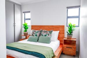 a bedroom with a bed with two plants on it at Jackal Creek Golf Estate- Luxury comfortable home in Roodepoort +28 photos
