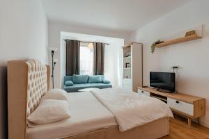 a bedroom with a bed and a tv and a couch at Blvd Ivory Pipera ap 25A in Bucharest