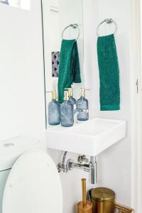 a bathroom with a white sink and green towels at Jackal Creek Golf Estate- Luxury comfortable home in Roodepoort