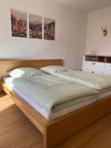 a bedroom with a bed with a wooden frame at Haus Schönblick in Krün +17 photos