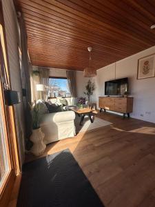 ein Wohnzimmer mit Sofa und Fernseher in der Unterkunft Küstenglück in Südbrookmerland