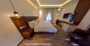 a hotel room with a bed and a television at Centurion Aparthotel in Abuja