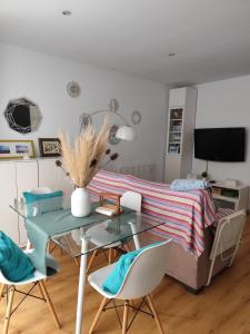 a room with a table and chairs and a bed at El apartamento de Fina in Gijón