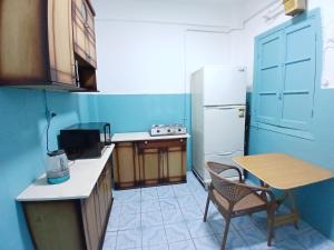 カイロにあるLively Cozy Downtown Roomのテーブルと冷蔵庫のある小さなキッチン