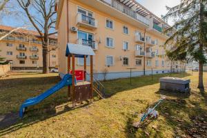 un parco giochi in un parco di fronte a un edificio di Útulný a štýlový apartmán v centre mesta a Prešov