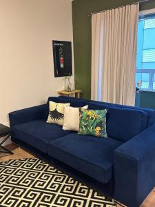 a blue couch with pillows in a living room at Apartamento familiar próximo à Universidade in Tubarão