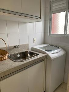 a small kitchen with a sink and a window at Apartamento familiar próximo à Universidade in Tubarão