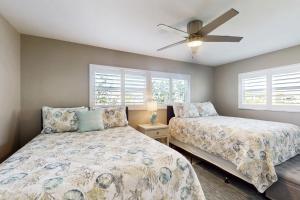 une chambre avec deux lits et un ventilateur de plafond dans l'établissement Caloosa Palms, à North Fort Myers 18 autres photos
