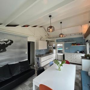 a living room with a white table and a kitchen at Nice chalet near Reeuwijkse plassen in Reeuwijk +13 photos
