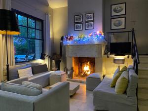 a living room with couches and a fireplace with christmas lights at maison week end vacances 1H Paris Ouest in Connelles