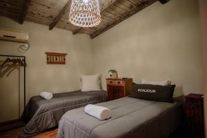 a room with two beds and a chandelier at Casa Josefina Hotel Boutique in Olavarría