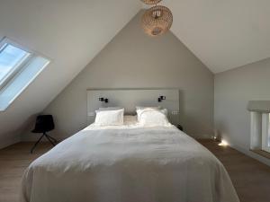 ドンブルグにあるVrijvakantiehuis Brouwerijweg 45aの屋根裏部屋にある大きな白いベッドのある寝室