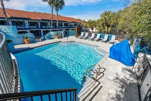 a swimming pool at a hotel with chairs around it at Beachside Inn in Destin