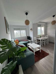 ein Wohnzimmer mit einem blauen Sofa und einem Tisch in der Unterkunft Una Parada en el Camino 3 in Fisterra