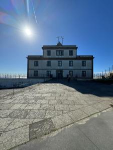 ein großes Gebäude auf einem Strand in der Unterkunft Una Parada en el Camino 3 in Fisterra + 45 Fotos