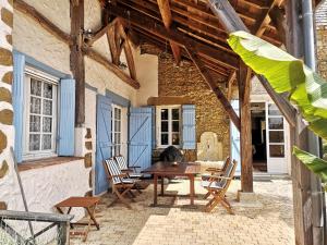 an outdoor patio with a wooden table and chairs at Chez Jay à Bassoues in Bassoues