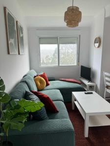 ein Wohnzimmer mit 2 grünen Sofas und einem Tisch in der Unterkunft Una Parada en el Camino 3 in Fisterra