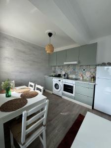 eine Küche mit einem Tisch und einem weißen Kühlschrank in der Unterkunft Una Parada en el Camino 3 in Fisterra