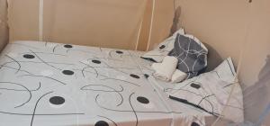 a bed with black and white sheets and pillows at Vue mer et montagne in Vieux-Habitants