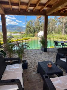 a patio with couches and tables and a view of a fence at Glamping Pozo Azul, Villa de Leyva in Villa de Leyva +32 photos