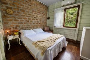 Katil atau katil-katil dalam bilik di Casa Rústica com Piscina Privativa, Banheira de Hidromassagem, Ar-Condicionado, Pet friendly - Refúgio na Natureza a 5 Minutos do Centro de Imbituba, Perfeita para Famílias e Grupos +53 gambar