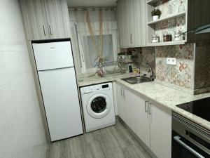 a kitchen with a white refrigerator and a washing machine at San Andres 14 in Teruel +5 photos