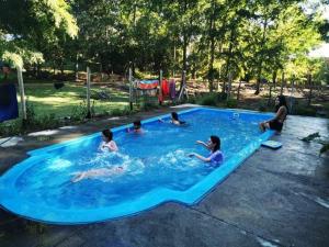 a group of children playing in a swimming pool at Refugio Pucura in Pucura