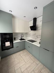 a white kitchen with a sink and a stove at Торайгырова 89 in Pavlodar +8 photos
