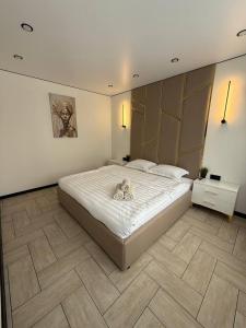 a bedroom with a bed with a teddy bear on it at Торайгырова 89 in Pavlodar