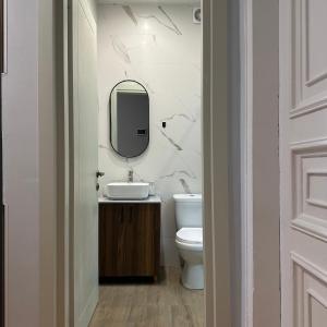 a bathroom with a sink and a mirror and a toilet at Kutaisi Central Square in Kutaisi