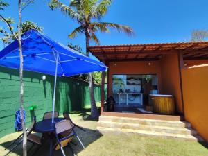 a patio with a table and a blue umbrella at Loft BeiraMar 2 in Serra