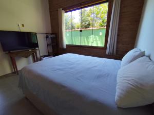 a bedroom with a white bed and a window at Loft BeiraMar 1 in Serra