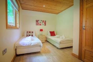 a bedroom with two beds and a window at Fern Gully Lodge with Hot Tub - Spa Resort - Devon in Chudleigh