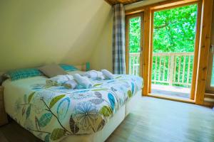 a bedroom with a bed and a window with a porch at Fern Gully Lodge with Hot Tub - Spa Resort - Devon in Chudleigh