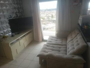 a living room with a couch and a large window at Condominio Mirante do Lago in Ananindeua