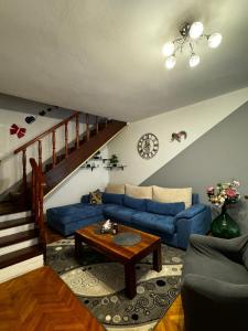 a living room with a blue couch and a table at Apartman Nonno Božo 2 in Fažana