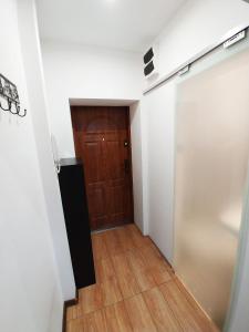 a hallway with a wooden door and a wooden floor at Śliczny Apartament obok Manufaktury na wyłączność, parter, blok, in Łódź