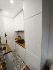 a small kitchen with white cabinets and a sink at Śliczny Apartament obok Manufaktury na wyłączność, parter, blok, in Łódź