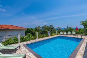 Una piscina con tumbonas al lado de una casa. en Villa Sandra, a beautiful villa with sea view and a pool, en Drenje