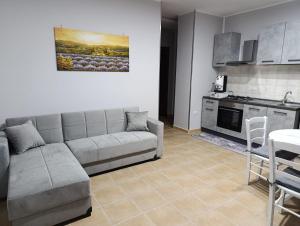 a living room with a couch and a kitchen at Le follie in Maddaloni