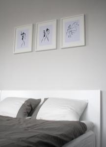 グダニスクにあるApartament-31のベッドの上に3枚の写真が飾られたベッドルーム1室
