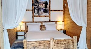 a bed in a room with white curtains at Etno wooden room in Rakovica