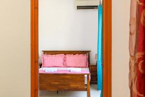 a mirror in a room with a bench with a pink cushion at D&A Alex Studios in Papoutsíras