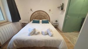 a bedroom with a large white bed with blue pillows at La cachette audomaroise avec sa terrasse in Saint-Omer