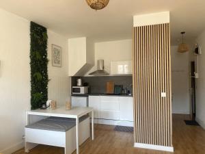 a kitchen with a white table and a white counter at Appartement cosy au coeur de la ville d'Auch in Auch
