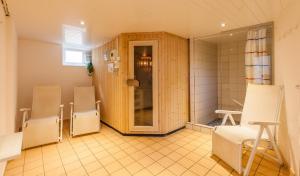 a group of chairs in a room with a shower at Kleine Brise mit Meerblick und Schwimmbad in Kronsgaard +11 photos